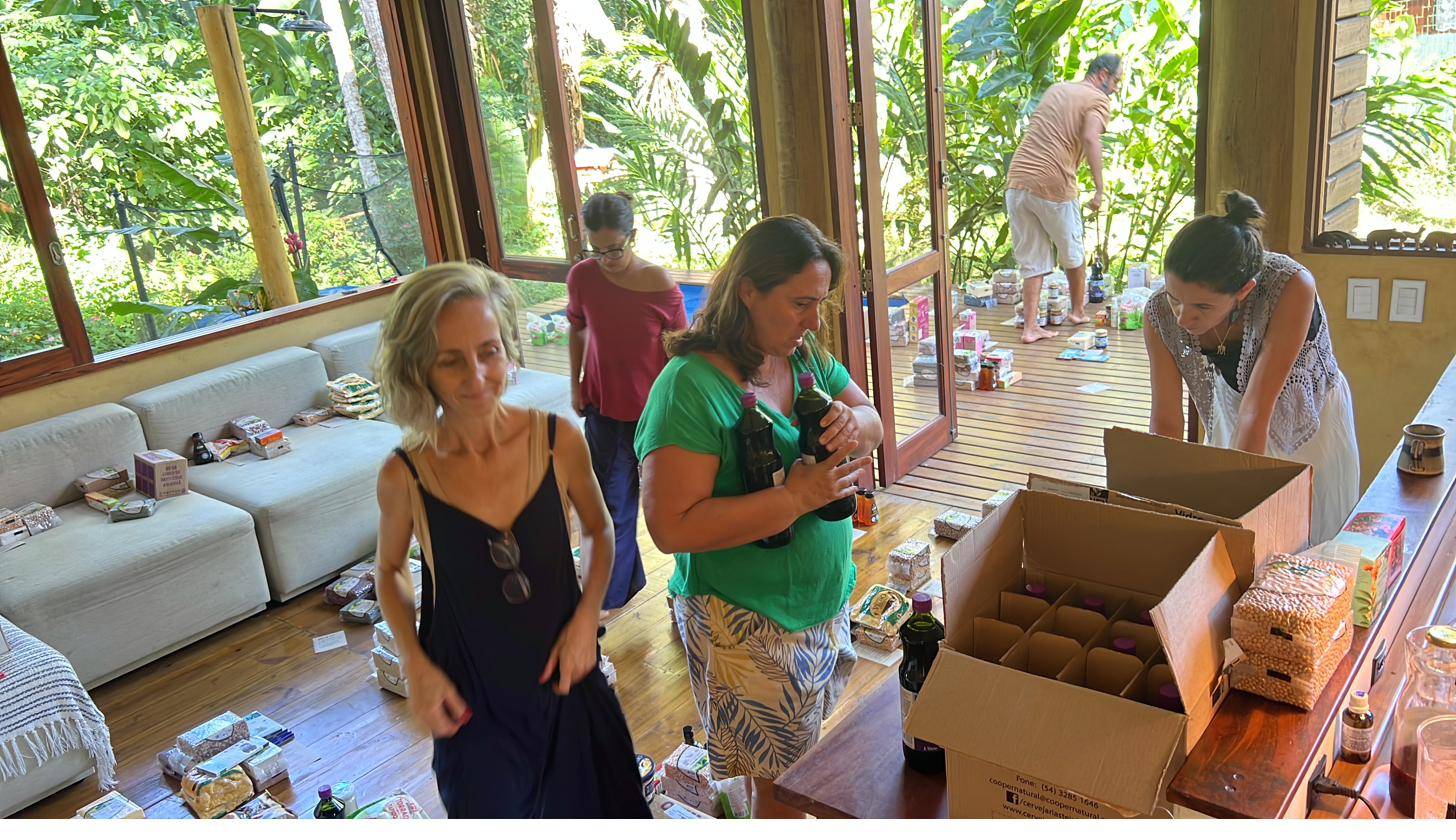Pessoas separando produtos em caixas durante o mutirão de separação do Núcleo Ressaca, em Ubatuba